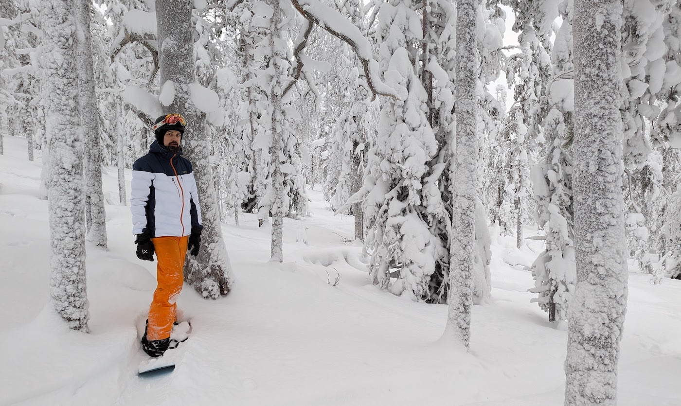 Teemu Saarelainen seisoo lumilaudan päällä lumisessa metsässä